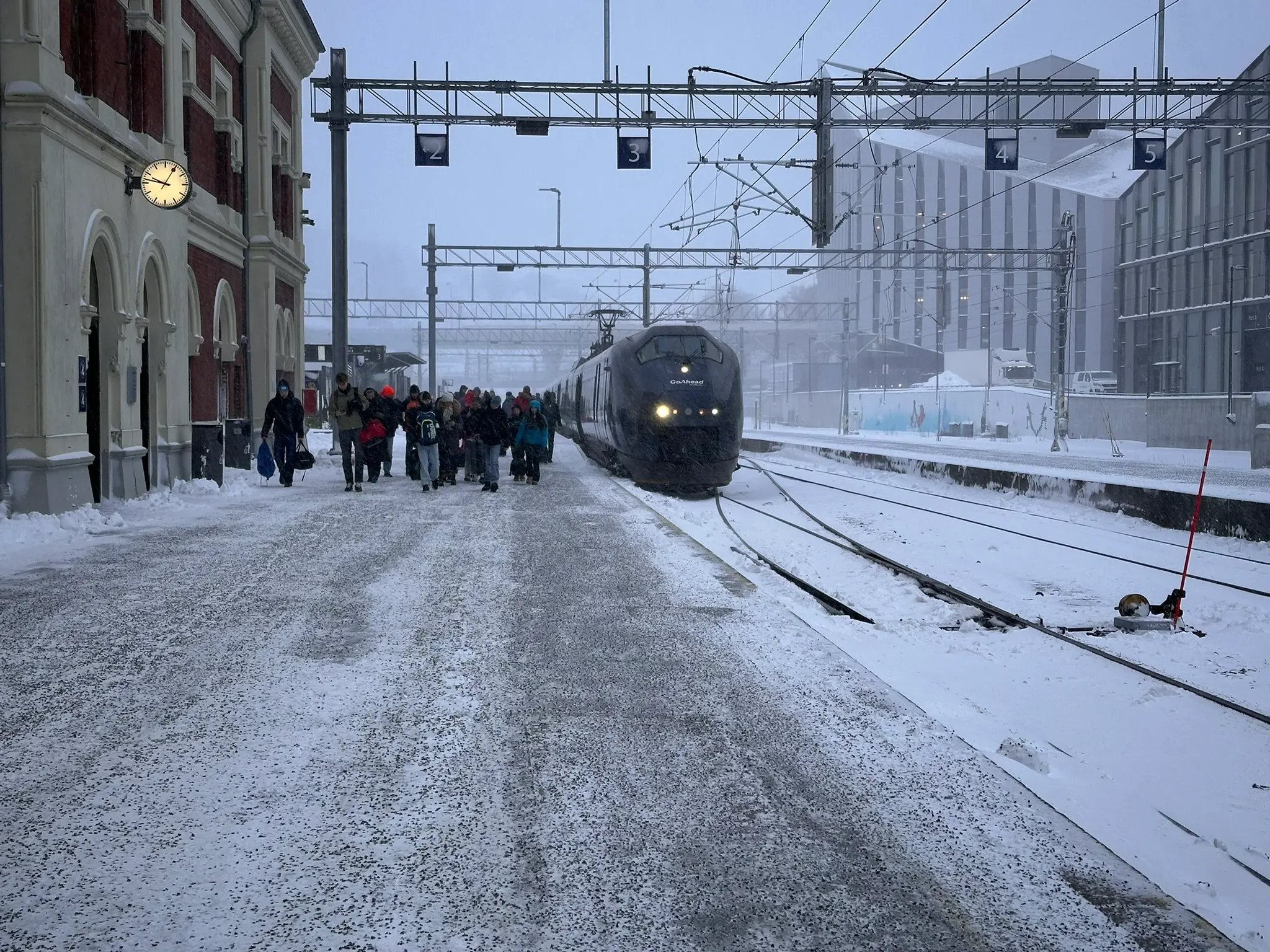 Laget ankommer med tog i et snødekt Kristiansand